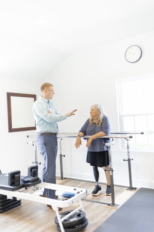 Will Nutt, PT, DPT, working with a patient at the parallel bars in Roxboro, NC