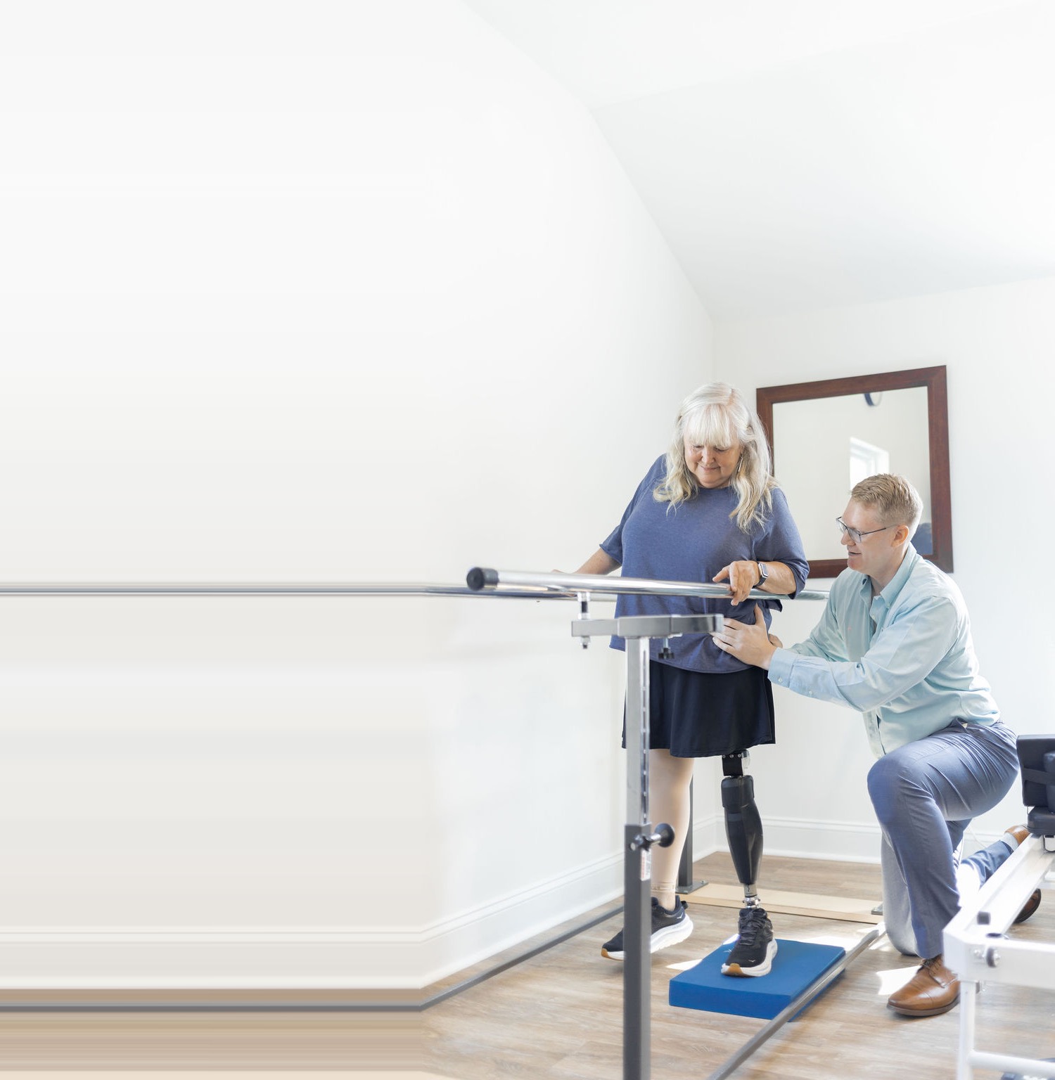 Will Nutt, PT, DPT, guiding a patient through gait training at the parallel bars at Concierge Physical Therapy in Roxboro, NC